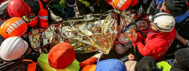 Menschen begraben die Toten. - Foto: Emrah Gurel/AP/dpa
