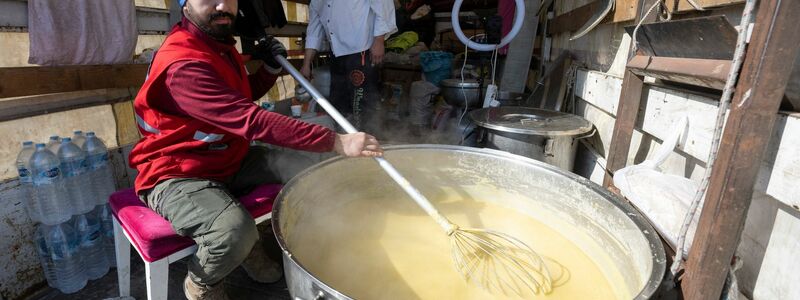 Tuncay Ilker kocht auf der Ladefläche eines Lkw in Kahramanmaras eine Suppe. - Foto: Boris Roessler/dpa