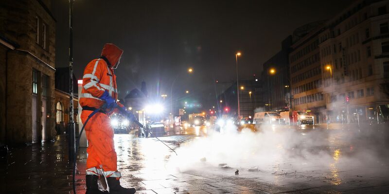Arbeiten in der Dunkelheit: Ein Mitarbeiter der Stadtreinigung in Hamburg. - Foto: Christian Charisius/dpa