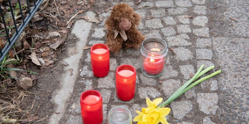 Kerzen und Blumen stehen unweit der Stelle, an der das verletzte Mädchen gefunden wurde. Trotz Reanimation verstarb es. - Foto: Paul Zinken/dpa