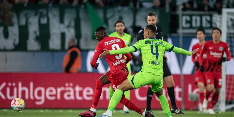 Wolfsburgs Jonas Wind (r) ließ Eintracht-Keeper Kevin Trapp beim 1:0 keine Chance. - Foto: Swen Pförtner/dpa