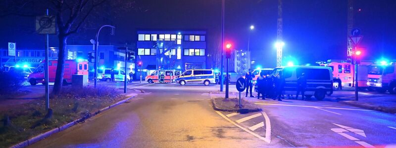 Polizisten in Spezialausrüstung stehen neben einem Gebäude der Zeugen Jehovas in Hamburg. - Foto: Jonas Walzberg/dpa