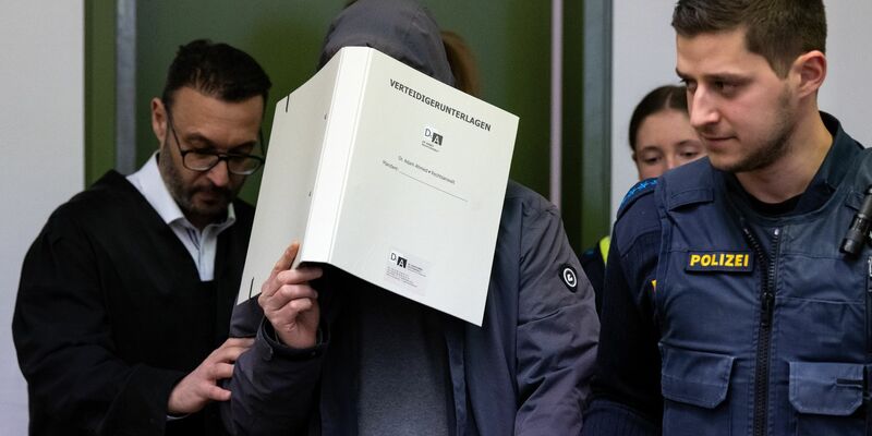 Der wegen des Besitzes und der gewerbsmäßigen Verbreitung von Kinderpornografie Angeklagte wird vor Prozessbeginn in den Gerichtssaal geführt. - Foto: Sven Hoppe/dpa