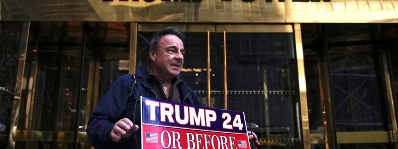 Ein Trump-Anhänger steht vor dem Trump Tower in New York und zeigt seine Unterstützung mit einem Schild. - Foto: Bryan Woolston/AP/dpa