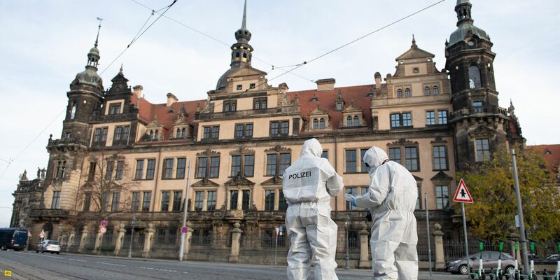Zwei Mitarbeiter der Spurensicherung stehen vor dem Residenzschloss mit dem Grünen Gewölbe. - Foto: Sebastian Kahnert/dpa