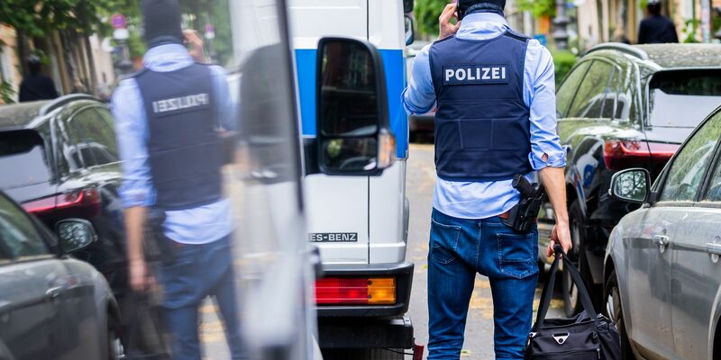 Polizisten tragen bei einer Hausdurchsuchung im Mai 2023 in Berlin-Kreuzberg einen Karton zu einem Fahrzeug. - Foto: Christoph Soeder/dpa