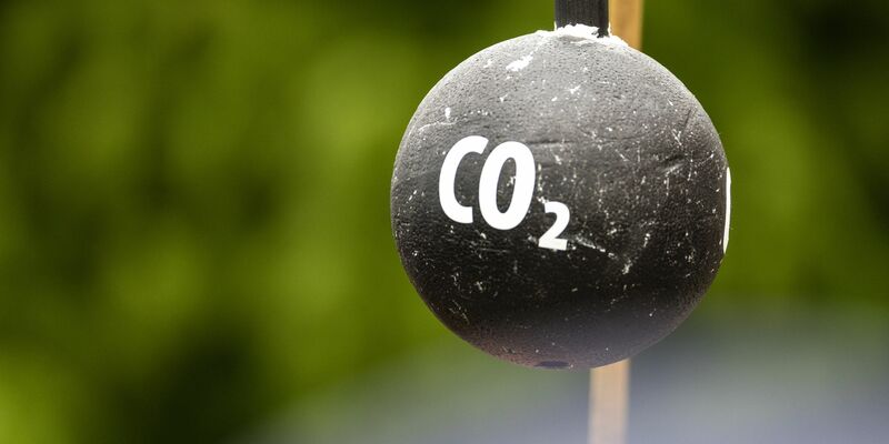 An einem Stab hängt vor Beginn einer Demonstration in Sachsen symbolisch eine «CO2-Bombe». - Foto: Frank Hammerschmidt/dpa