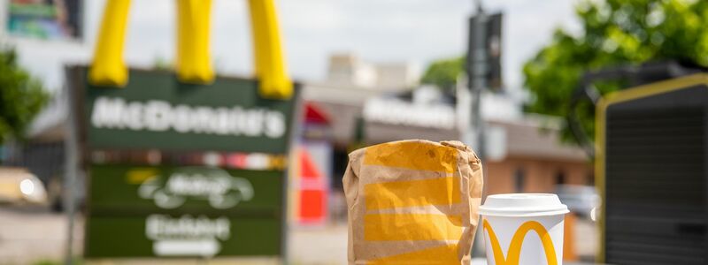 Eine McDonald's To-go-Tüte und ein dazugehöriger To-go-Becher stehen vor einer Tübinger McDonald's Filiale. - Foto: Christoph Schmidt/dpa