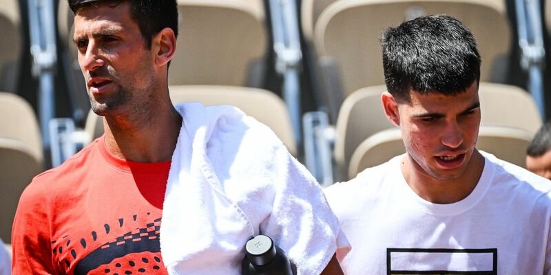 Novak Djokovic (l) aus Serbien und Carlos Alcaraz aus Spanien gehen nebeneinander während einer Trainingseinheit für die French Open 2023. - Foto: Matthieu Mirville/ZUMA Press Wire/dpa