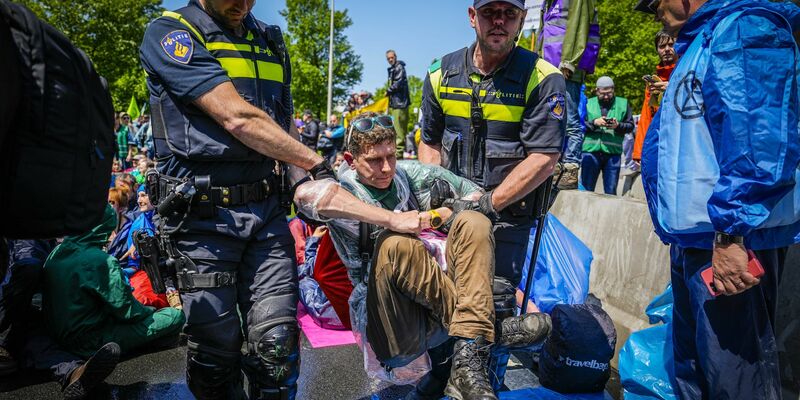 Die Polizei trägt Aktivisten von Extinction Rebellion weg, die die A12 in Den Haag blockieren. - Foto: Phil Nijhuis/ANP/dpa