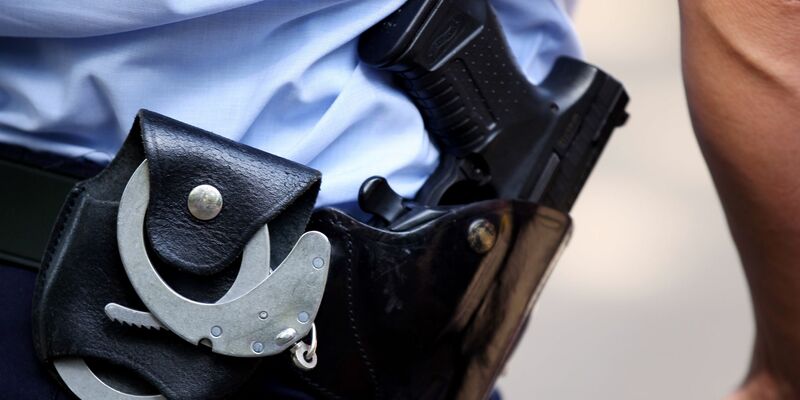 Ein Polizist trägt Handschellen bei sich: Die Bundespolizei hat mutmaßliche Schleuser festgenommen. - Foto: Oliver Berg/dpa/Symbolbild