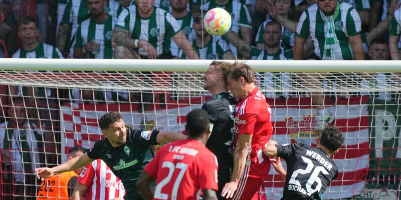 Werder Bremens Marco Friedl (l) und Unions Kevin Behrens im Kopfballduell. - Foto: Soeren Stache/dpa