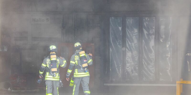 Kräfte der Feuerwehr verschaffen sich nach der Explosion in einer Industriehalle einen Überblick. - Foto: Tim Oelbermann/dpa