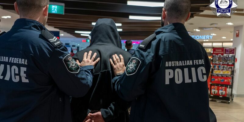 Polizisten führen den Schmuggler ab. - Foto: Supplied/Australian Federal Police AFP/AAP/dpa