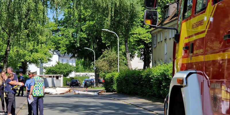 Trümmer liegen auf der Straße nach dem Absturz eines Segelflugzeugs im Stadtgebiet von Wetzlar. - Foto: Carolin Eckenfels/dpa