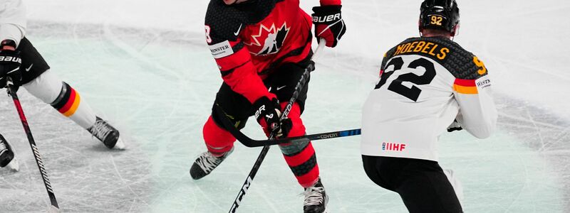 Kanadas Cody Glass (M) muss sich auf dem Eis gegen Marcel Noebels behaupten. - Foto: Pavel Golovkin/AP/dpa