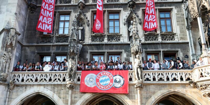 Die Spielerinnen und Spieler des FC Bayern feiern gemeinsam auf dem Rathaus-Balkon. - Foto: Karl-Josef Hildenbrand/dpa