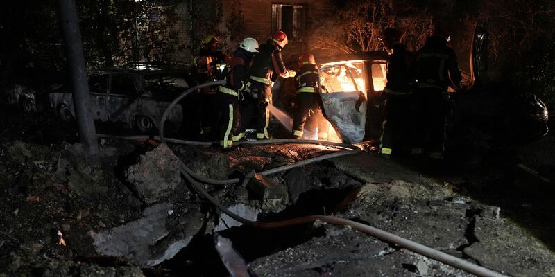 Rettungskräfte löschen in einem geparkten Auto ein Feuer, das nach einem russischen Luftangriff im Kiewer Pecherskyi-Viertel durch herabfallende Trümmer verursacht wurde. - Foto: Roman Hrytsyna/AP