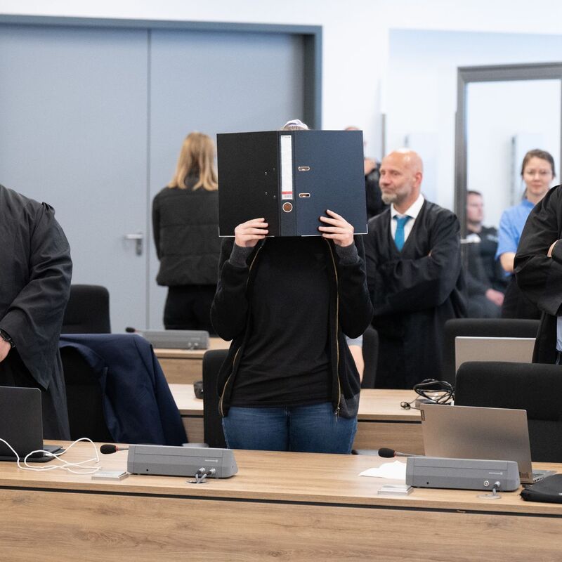 Die Angeklagte (M) steht bei der Fortsetzung des Prozesses im OLG Dresden im Verhandlungssaal. - Foto: Sebastian Kahnert/dpa