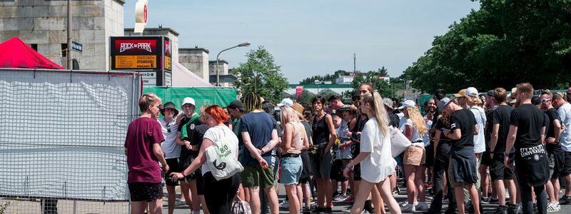 Besucherinnen und Besucher warten vor Beginn des Open-Air-Festivals Rock im Park auf den Einlass. - Foto: Daniel Vogl/dpa
