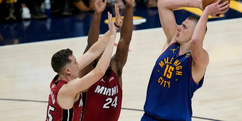 Denvers Nikola Jokic (r) wirft über Miamis Duncan Robinson (l) und Haywood Highsmith. - Foto: David Zalubowski/AP/dpa