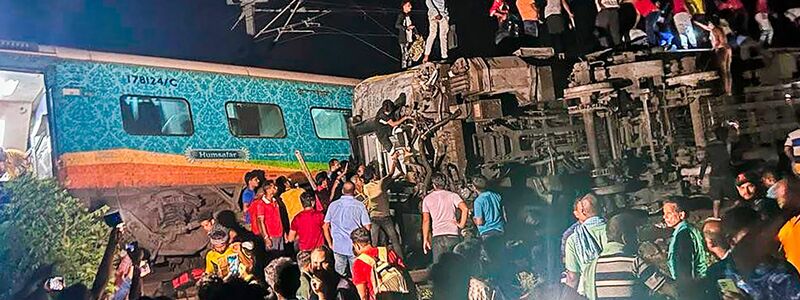 Rettungskräfte arbeiten an der Stelle, an der ein Personenzug im ostindischen Bundesstaat Orissa entgleist ist. - Foto: ---/Press Trust of India/dpa