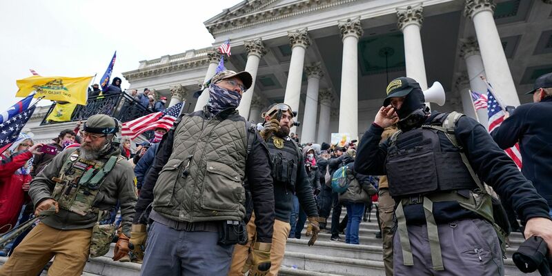 Mitglieder der rechtsextremen Miliz «Oath Keepers» stehen am US-Kapitol. - Foto: Manuel Balce Ceneta/AP/dpa