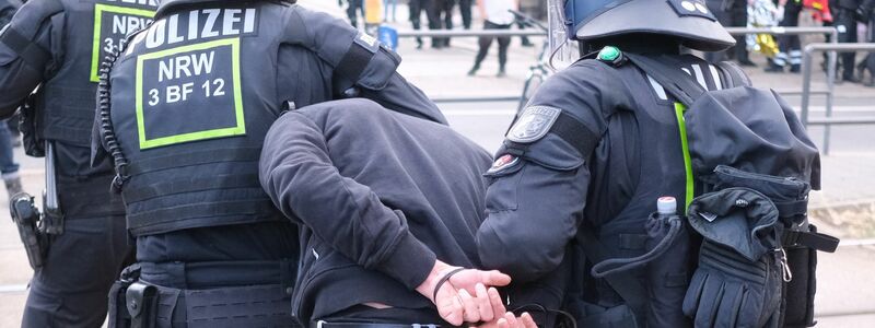 Polizisten habe einen Mann in Gewahrsam genommen. - Foto: Sebastian Willnow/dpa