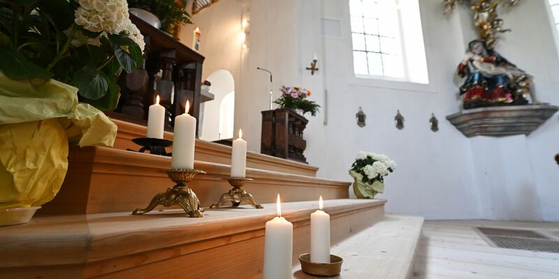 In der Wallfahrtskirche St. Anton in Garmisch-Partenkirchen stehen fünf Kerzen zum Gedenken an die Todesopfer. - Foto: Angelika Warmuth/dpa
