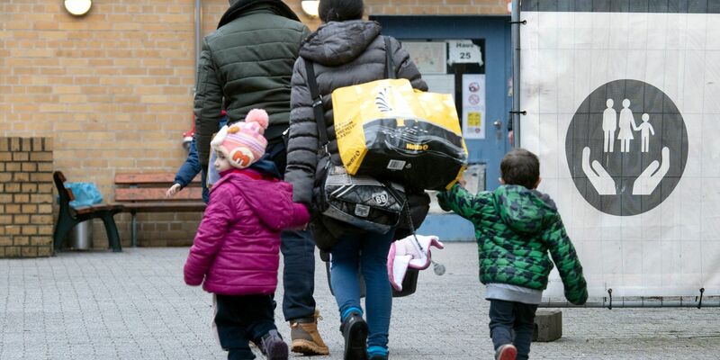 Aus ihrer Heimat geflohene Menschen betreten das Gelände einer Erstaufnahmeeinrichtung in Berlin. - Foto: Paul Zinken/dpa