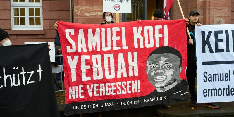 Der Asylbewerber Samuel Yeboah aus dem westafrikanischen Ghana wurde bei dem Anschlag getötet. Beim Auftakt des Prozesses 2022 machen Demonstranten darauf aufmerksam. - Foto: Thomas Frey/dpa