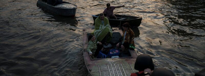 Rettungskräfte versuchen, Boote mit Bewohnern abzuschleppen. - Foto: Felipe Dana/AP/dpa