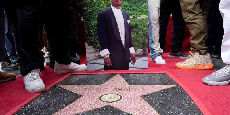 Ein Bild des verstorbenen Rappers und Schauspielers Tupac Shakur steht neben seinem Stern auf dem Hollywood Walk of Fame. - Foto: Chris Pizzello/Invision/AP/dpa