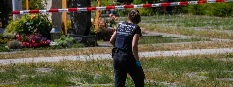 Die Polizei am Tatort auf einem Friedhof. - Foto: Christoph Schmidt/dpa