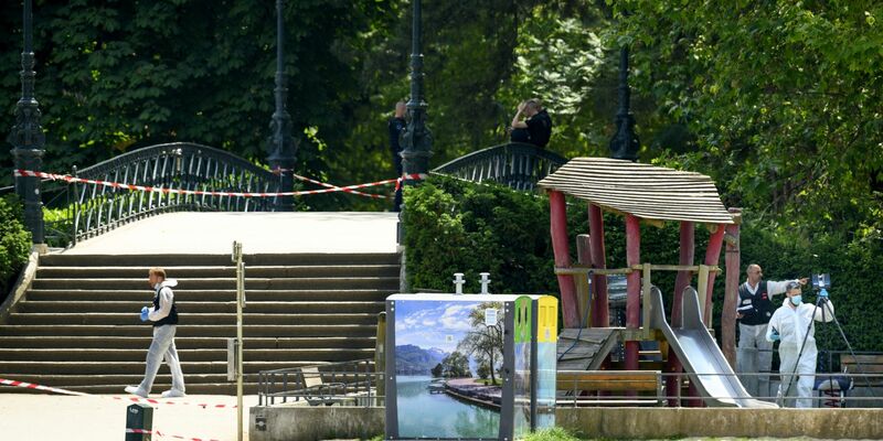 Polizisten ermitteln am Tatort nach einem Messerangriff in einem Park in Annecy. - Foto: Jean-Christophe Bott/KEYSTONE/dpa