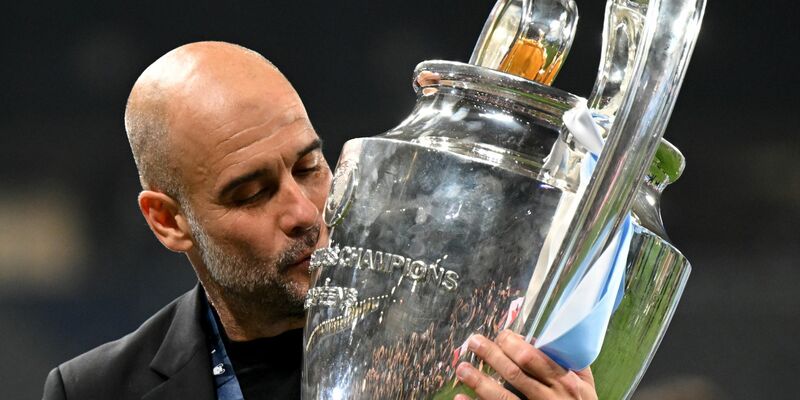Manchesters Trainer Pep Guardiola küsst die Trophäe. - Foto: Robert Michael/dpa