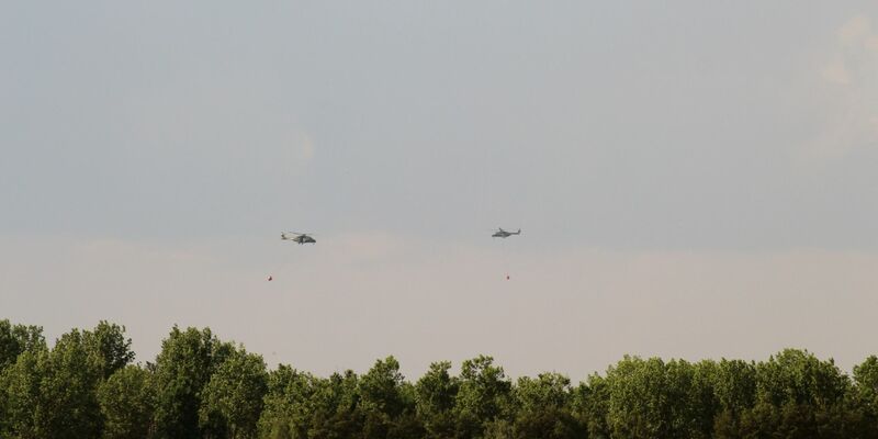 Hubschrauber der Bundeswehr und Bundespolizei überfliegen überfliegen das Waldbrandgebiet Forst Zinna bei Jüterbog und löschen aus der Luft. - Foto: Christian Pörschmann/dpa