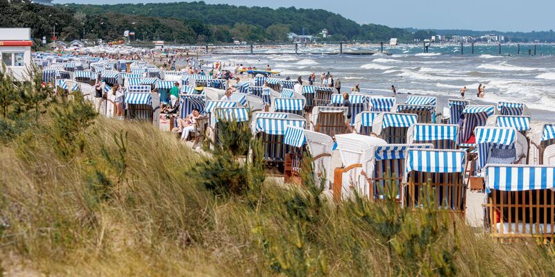 Bei Sonnenschein und starkem Wellengang ist die Wasserkante von Timmendorfer Strand gut besucht. - Foto: Markus Scholz/dpa