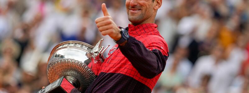Novak Djokovic freut sich mit der Trophäe über den Sieg bei den French Open. - Foto: Thibault Camus/AP/dpa