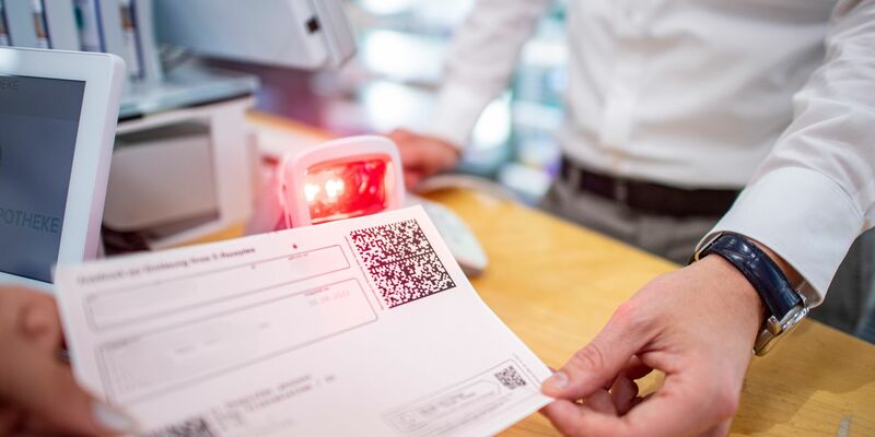 Ein Apotheker scannt den QR-Code eines E-Rezepts ein. - Foto: David Inderlied/dpa