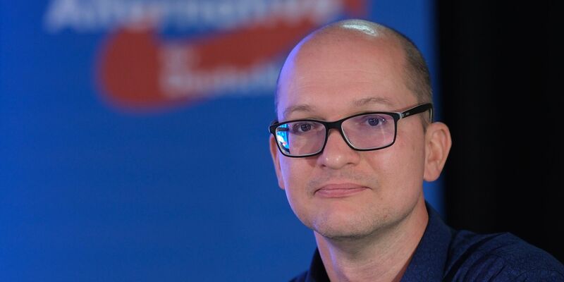 Thüringer AfD-Landessprecher Stefan Möller sitzt beim Landesparteitag nach seiner Wiederwahl auf der Bühne. - Foto: Sebastian Willnow/dpa