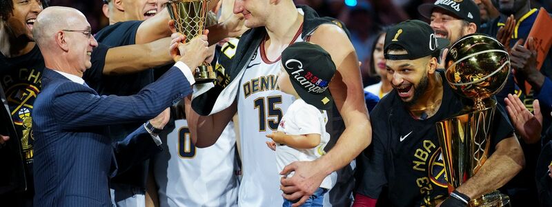 NBA-Commissioner Adam Silver (l) überreicht die MVP-Trophäe an Nuggets-Center Nikola Jokic (M.). - Foto: Jack Dempsey/AP/dpa