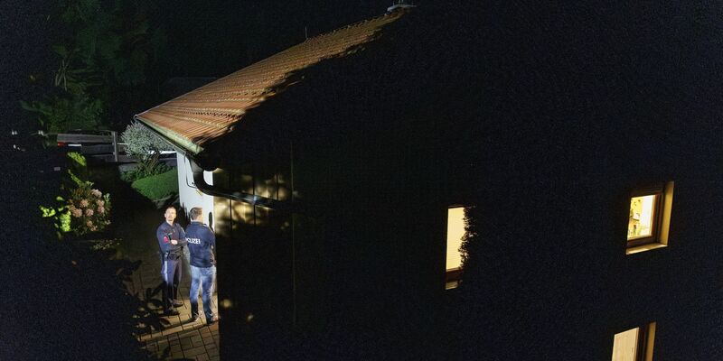 Polizisten stehen während der Ermittlungen vor dem Wohnhaus, in dem drei Leichen gefunden wurden. - Foto: Erwin Scheriau/APA/dpa