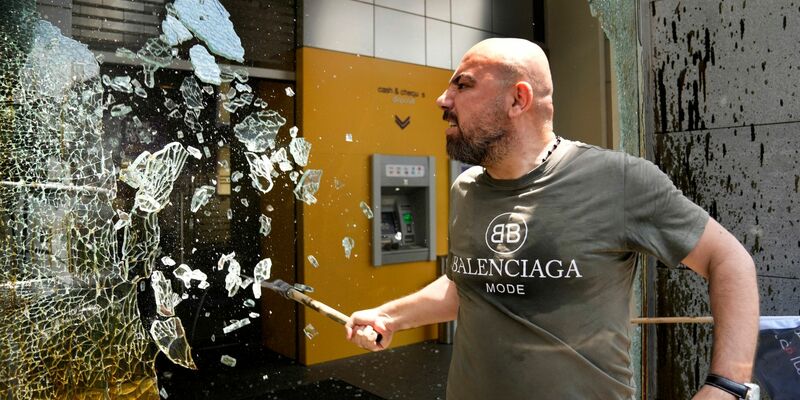 «Die Banken im Libanon stehlen unser Geld!»: Ein Demonstrant zerschlägt Fensterscheiben der Byblos Bank. - Foto: Hussein Malla/AP/dpa