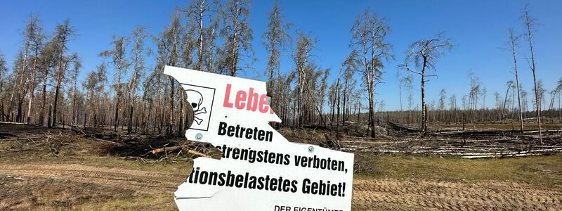 Beschädigt ist ein Warnschild am mit Munition belasteten Waldbrandgebiet bei Lübtheen. Der Waldbrand ist unter Kontrolle. - Foto: Steven Hutchings/TNN/dpa