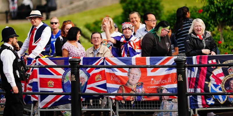 Menschen warten auf der Prachtstraße «The Mall» in London auf den Beginn der Parade «Trooping the Colour». - Foto: Victoria Jones/PA Wire/dpa
