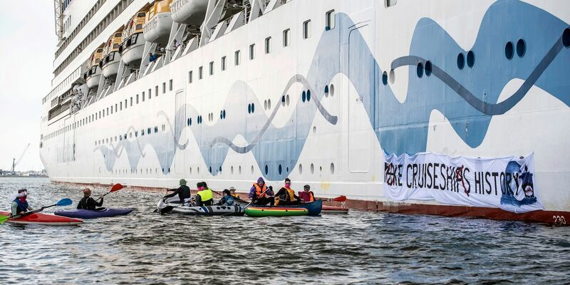 Klimaaktivisten versuchen, das Kreuzfahrtschiff «Aida Diva» am Auslaufen zu hindern. - Foto: Frank Hormann/dpa