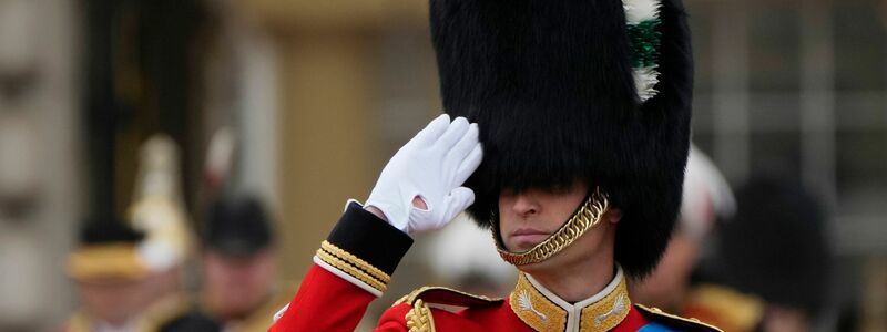 Thronfolger Prinz William trägt Bärenfellmütze und salutiert. - Foto: Alastair Grant/AP/dpa