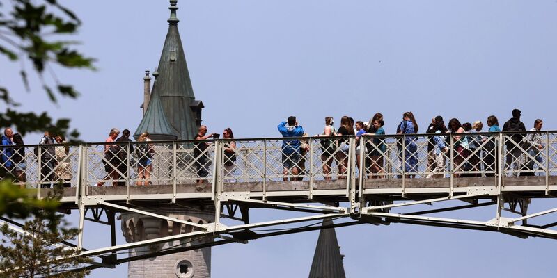 Touristen stehen auf der Marienbrücke vor dem Schloss Neuschwanstein. - Foto: Karl-Josef Hildenbrand/dpa