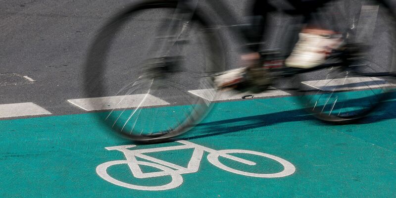 Eine Radfahrerin fährt in Leipzig über einen grün eingefärbten Radweg. - Foto: Jan Woitas/dpa